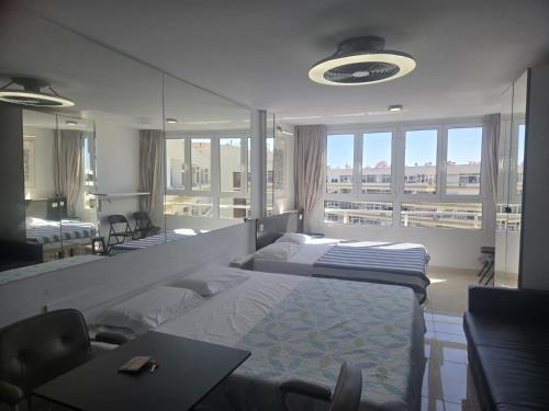 a bedroom with two beds and a large window at Loft Molinos Atalaya in San Bartolomé