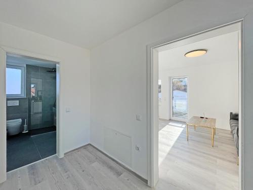 a white room with a door leading to a bathroom at Ferienwohnung Hochwangen in Ichenhausen