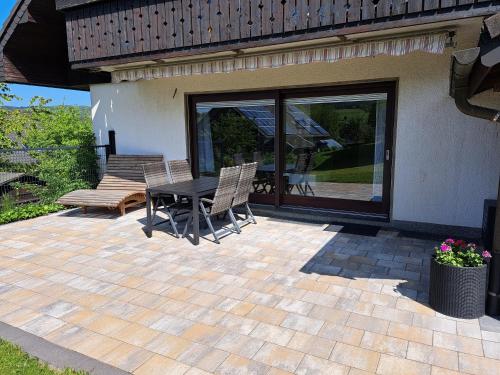 a patio with a table and chairs next to a house at Ferienwohnung Sauerland Feeling in Olsberg
