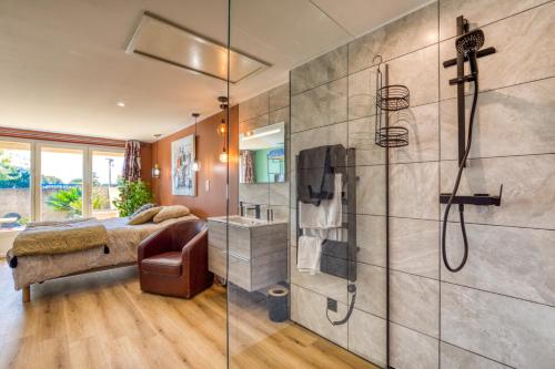 a master bathroom with a shower and a bed at Aux Amelierets in Saint-Just