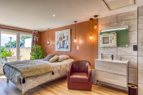 a bedroom with a bed and a sink and a chair at Aux Amelierets in Saint-Just