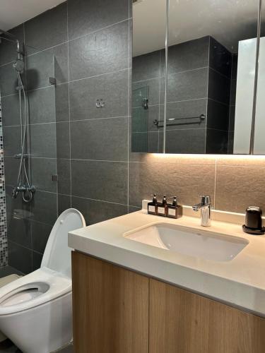 a bathroom with a sink and a toilet and a mirror at Căn hộ Republic Plaza gần Tân Sơn Nhất airport in Kon Rung (1)