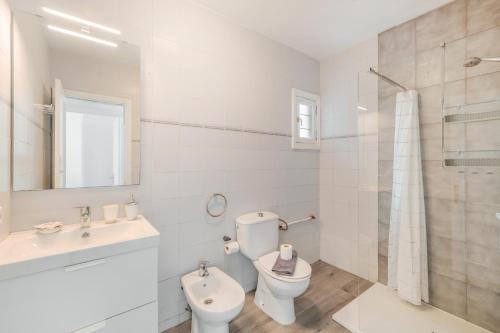a white bathroom with a toilet and a sink at Casa Real in Playa Blanca