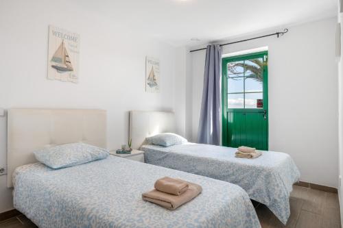 two beds with towels on them in a room at Casa Real in Playa Blanca