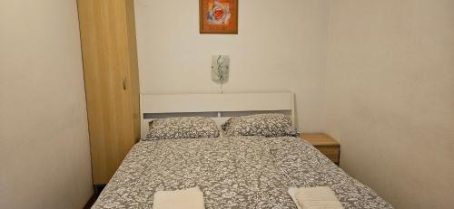 a small bedroom with a bed and a picture on the wall at Apartment Laguna 70 in Izola