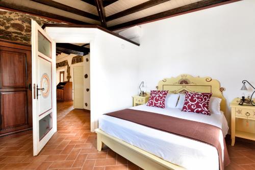 a bedroom with a large bed with red pillows at Casa sul lago private heated pool in Dorgali