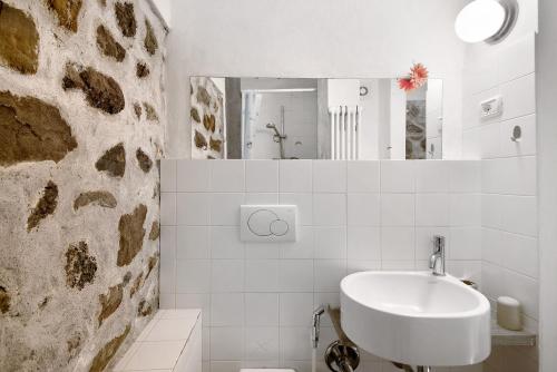 a white bathroom with a sink and a mirror at Beroni su due livelli in Bonassola