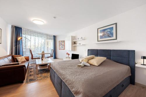 a bedroom with a large bed and a living room at Fewo Jutta in Uhldingen-Mühlhofen