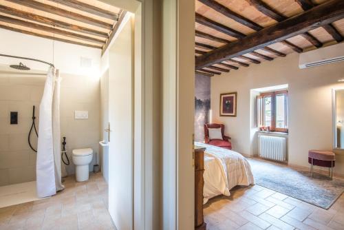 a bedroom with a bed and a toilet in a room at Brotes Appartamento Castagno in Sovicille