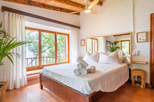 a bedroom with a large bed with a large window at Es Racó d'Alconàsser in Sóller