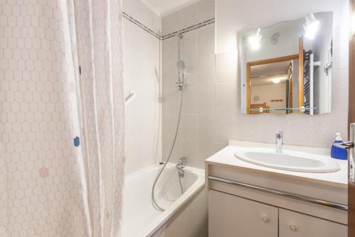 a white bathroom with a sink and a shower at T2 Bis - centre Barèges - cure in Barèges