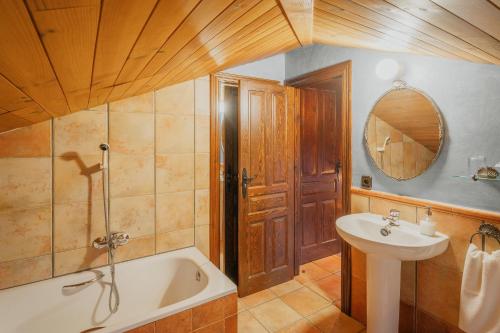 a bathroom with a tub and a sink and a mirror at La Morada del Cura in Calabazas