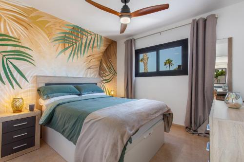 a bedroom with a bed with a palm tree mural at Casa de la Calma in Corralejo