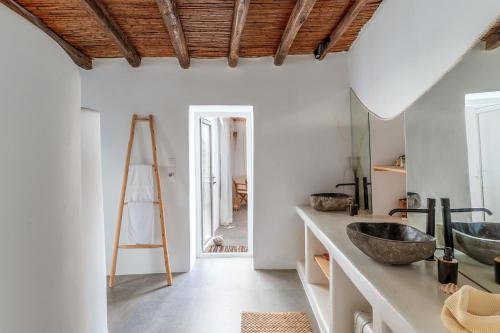 a bathroom with two sinks and a wooden ceiling at Lithos in Kóstos