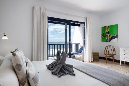 a bedroom with a bed with a view of the ocean at Malvasia 22 in Puerto Calero