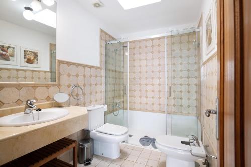 a bathroom with a toilet and a sink and a shower at Malvasia 22 in Puerto Calero