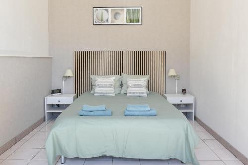 a bedroom with a large bed with blue towels on it at Domaine De L'olympe in Domart-en-Ponthieu