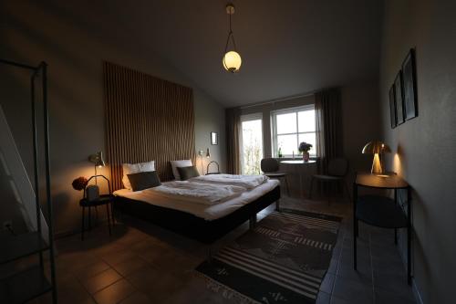 a bedroom with a bed and a table and a window at Ellevilde Boutique Hotel in Borre