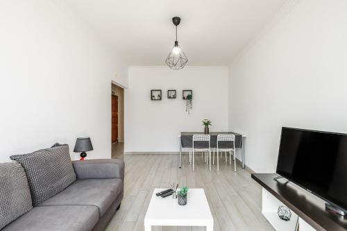 a living room with a couch and a flat screen tv at Sleeptubal Moderne Accommodatie in Alhos Vedros