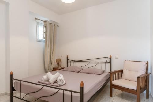 a bedroom with a bed and a chair at Anastasias Studios Mykonos in Plintri