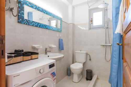 a bathroom with a washing machine and a sink at Anastasias Studios Mykonos in Plintri