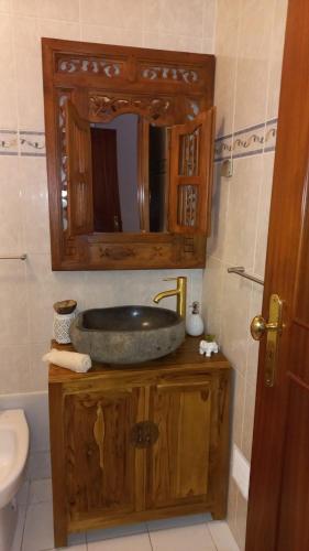 a bathroom with a wooden sink and a mirror at Vila Mourisca in Armação de Pêra