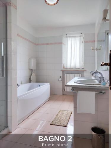 a white bathroom with a tub and a sink at Villa Gelsi a Pesaro in Pesaro
