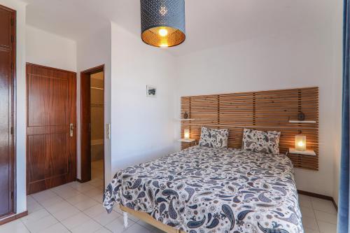 a bedroom with a large bed and a wooden headboard at Vila Mourisca in Armação de Pêra