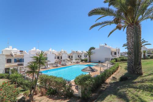 a villa with a swimming pool and palm trees at Vila Mourisca in Armação de Pêra
