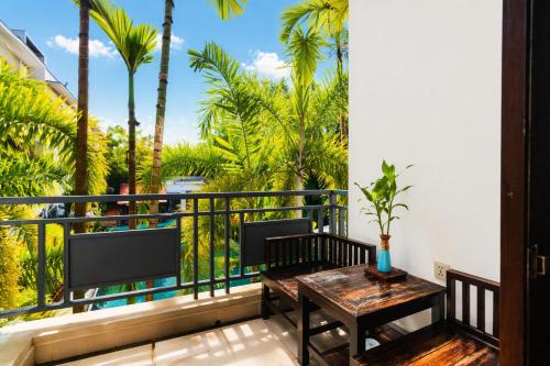 a balcony with a table and chairs and palm trees at Green Amazon Residence in Siem Reap