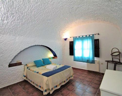 a bedroom with a bed in a room with a window at Los Jazmines in Benalúa de Guadix