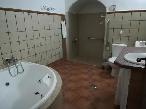 a bathroom with a tub and a toilet and a sink at Los Jazmines in Benalúa de Guadix