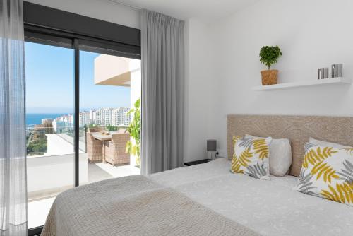 a bedroom with a bed and a view of the ocean at Penthouse Apt With Ocean View in Estepona