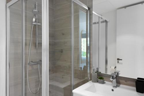 a bathroom with a glass shower with a sink at Penthouse Apt With Ocean View in Estepona