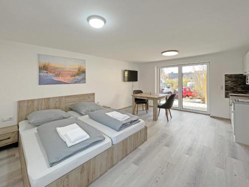a bedroom with a large bed and a table at Ferienwohnung Hochwangen in Ichenhausen
