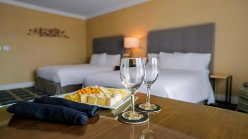 a hotel room with two beds and two glasses of wine at Grand Hotel in Sunnyvale