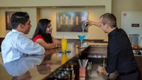 a man pouring a drink at a bar at Grand Hotel in Sunnyvale