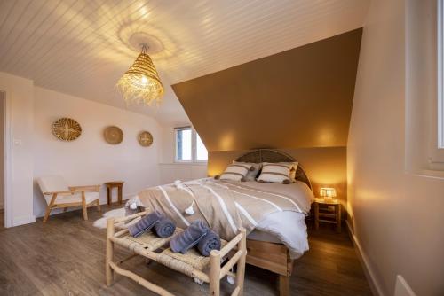 a bedroom with a large bed and a table at Lividig Bleue en face de la mer in Brignogan-Plage