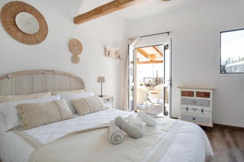 a bedroom with a white bed with towels on it at Las Golondrinas in Jedey