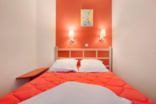 a bedroom with a bed with an orange wall at Appartement Cap Esterel St Raphaël in Saint-Raphaël