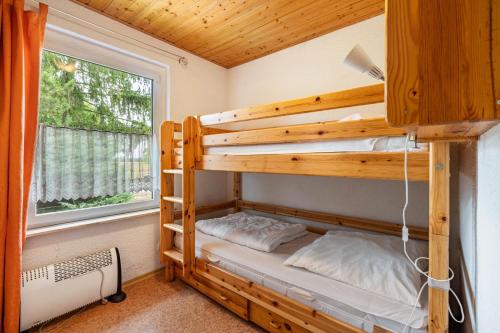 a bunk bed in a tiny house with a window at Bungalow 131 in Zeulenroda