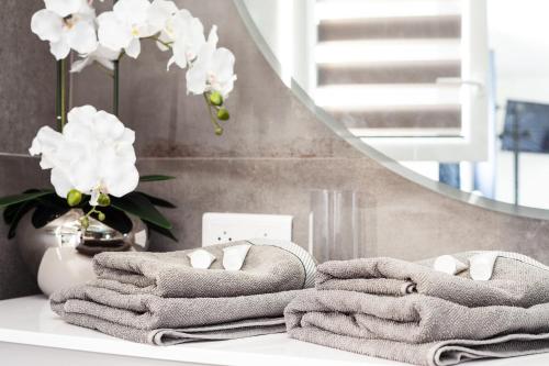 a pile of towels on a table with a mirror at Lucerta Bella in Aix-en-Provence