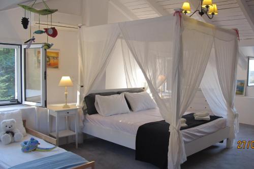 a bedroom with a bed with a canopy at Old Olive Press Sea and Mountain in Ágios Márkos