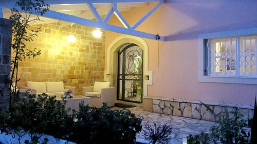 a house with a door in the middle of a yard at Old Olive Press Sea and Mountain in Ágios Márkos