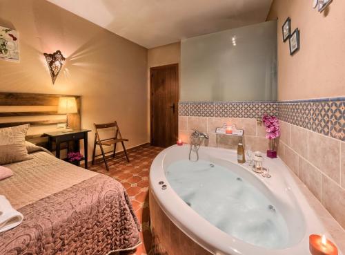 a bathroom with a tub next to a bed at Los Placeres Del Paladin in Zufre