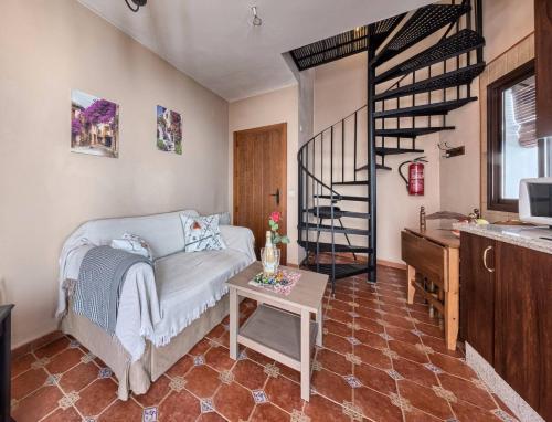 a living room with a couch and a spiral staircase at Los Placeres Del Paladin in Zufre