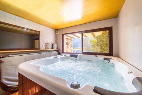 a large bath tub in a bathroom with a window at C´antonia Y Manuel in Laroya