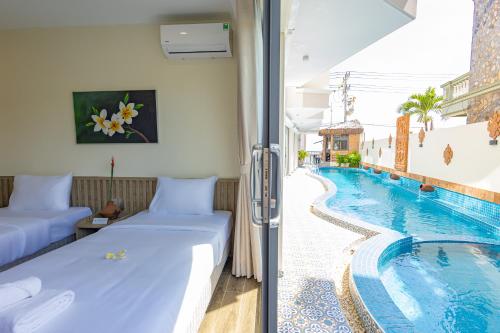 a hotel room with two beds and a swimming pool at Cham Charm Home Mui Ne in Ấp Thiện Phước