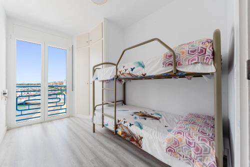 a bedroom with two bunk beds and a balcony at Vora Port in L'Ampolla