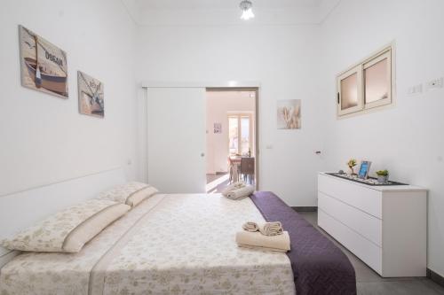a white bedroom with a large bed with towels on it at Casa Vacanze Lu Rizzaru in Nardò